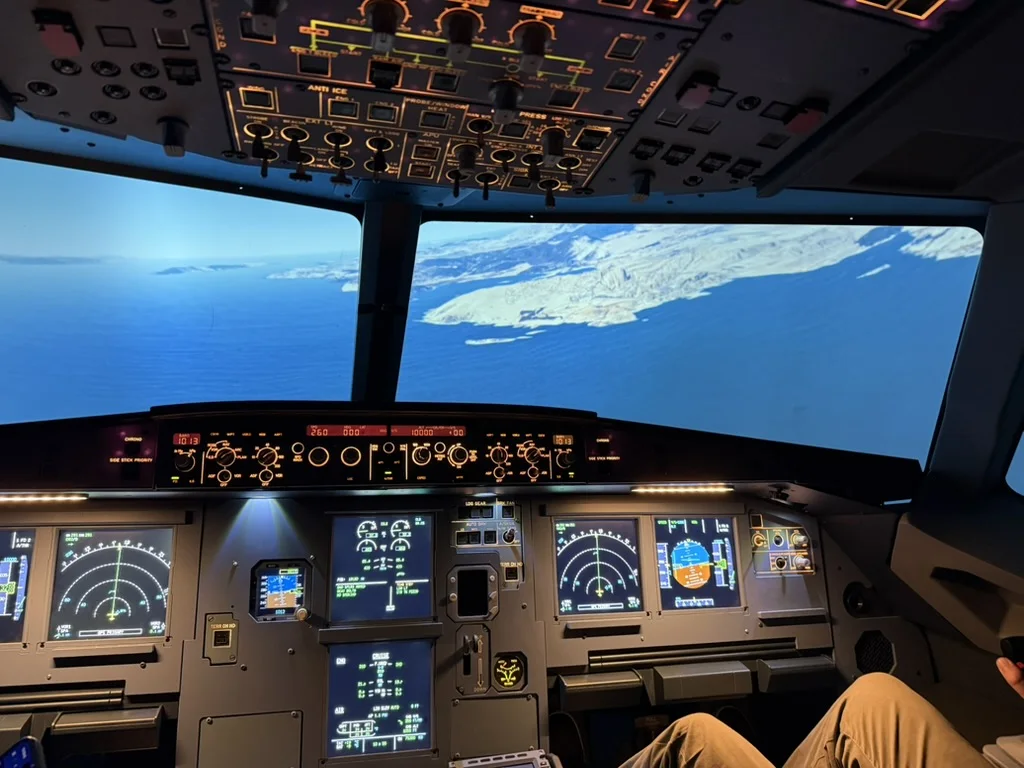 View from the A320 simulator flight deck over a coastline